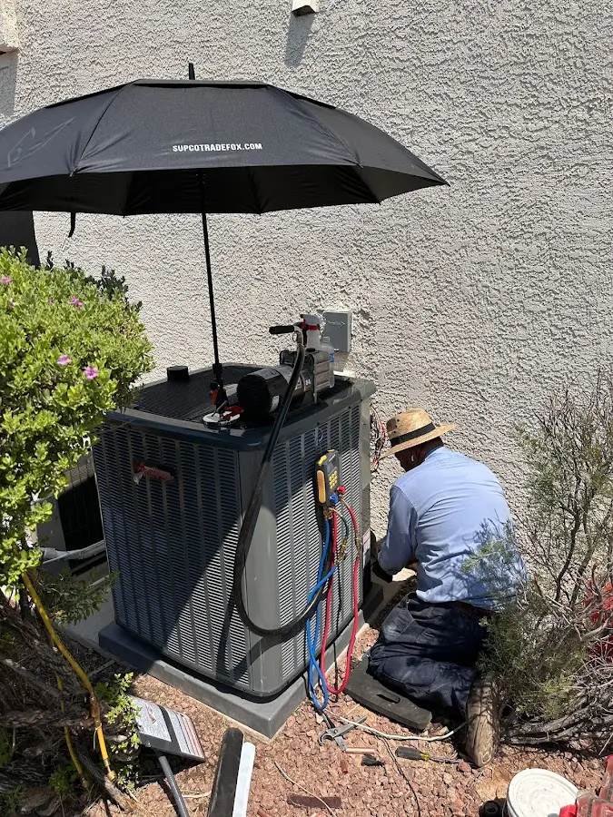 HVAC technician performing outdoor AC maintenance in Latimer