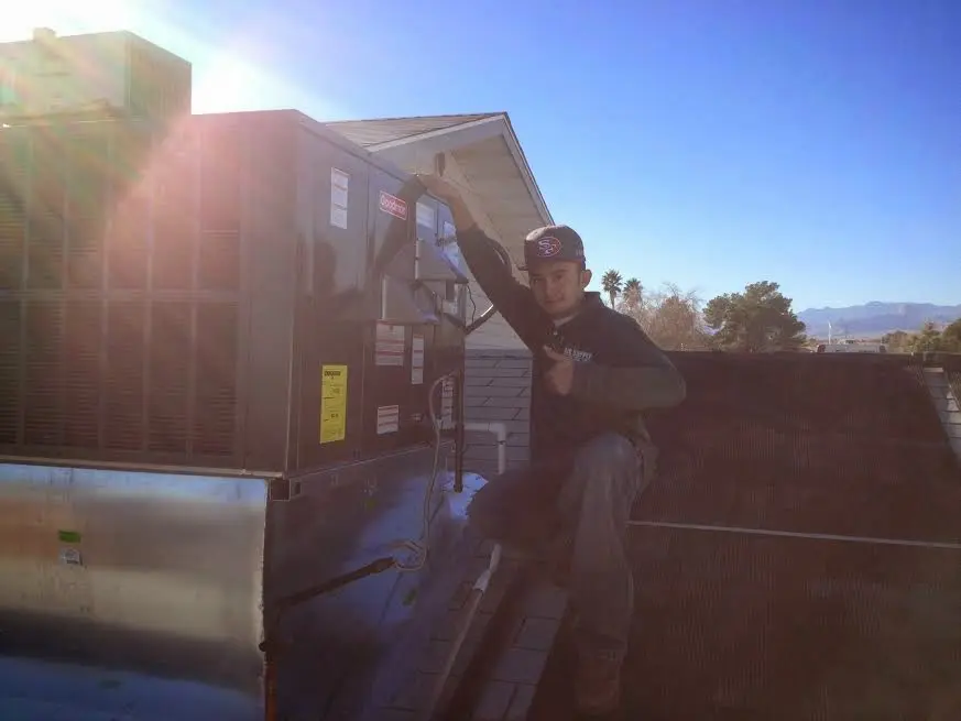 HVAC technician performing HVAC Inspection on a rooftop unit in Latimer